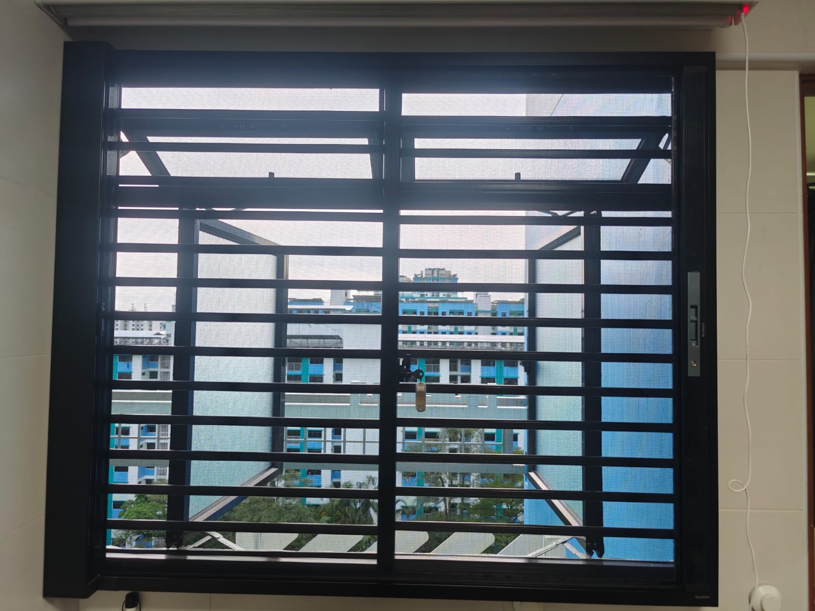 BlindXpert BX MultiPro Screen installed on an HDB casement window with an existing grille