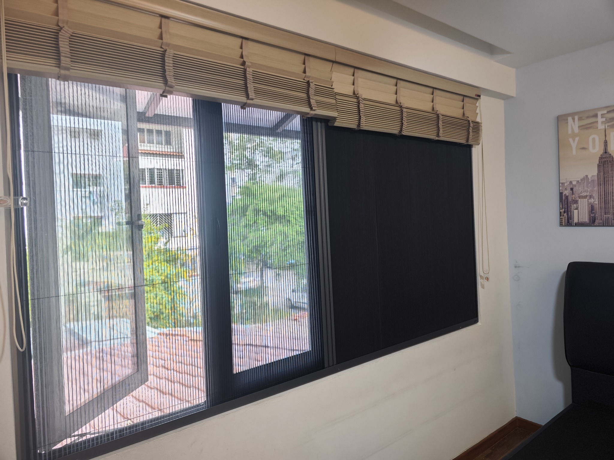 Two-in-one mosquito screen and dark sunshade installed across a wide window