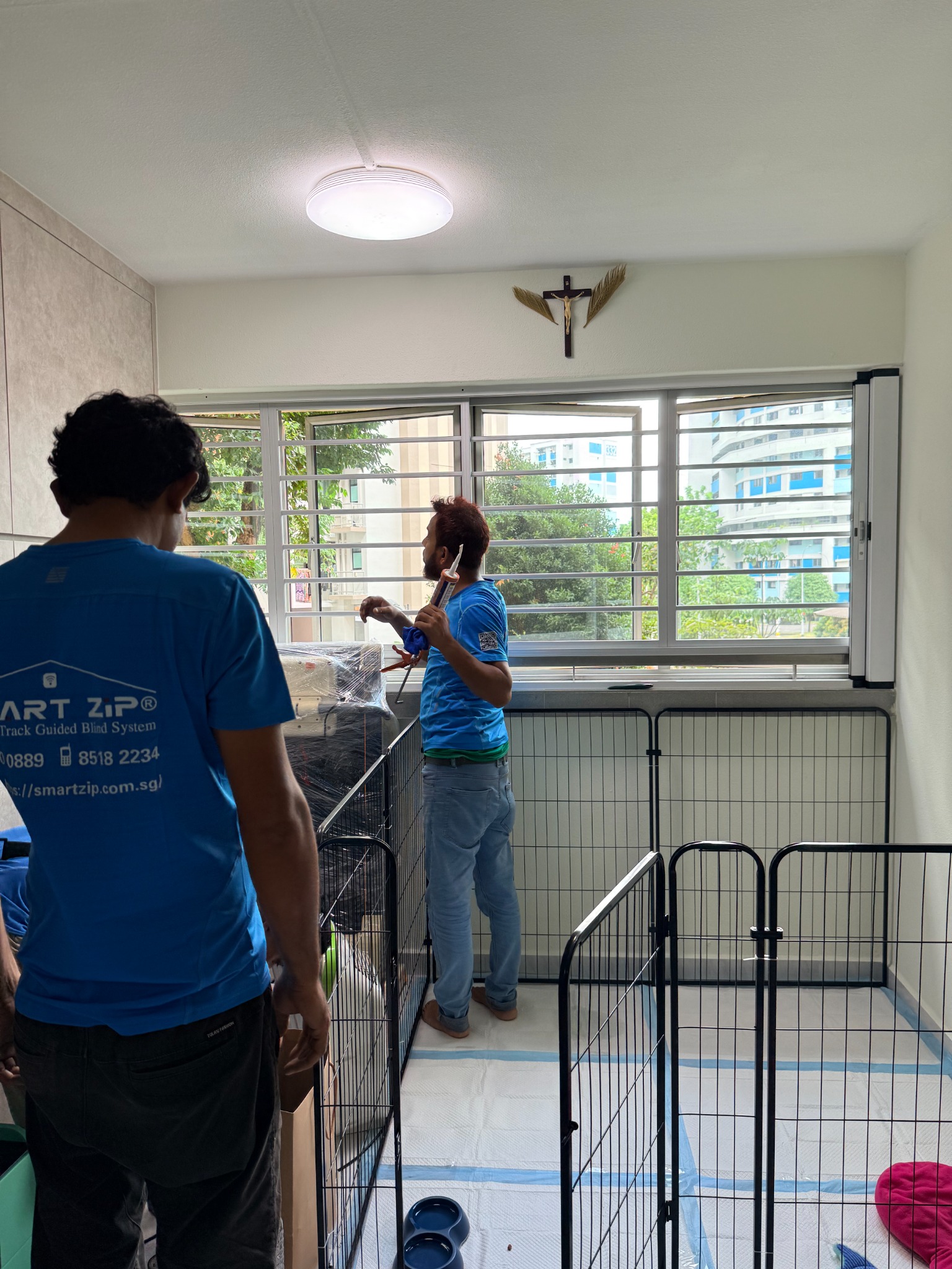 BlindXpert installer fitting a custom screen frame in a home