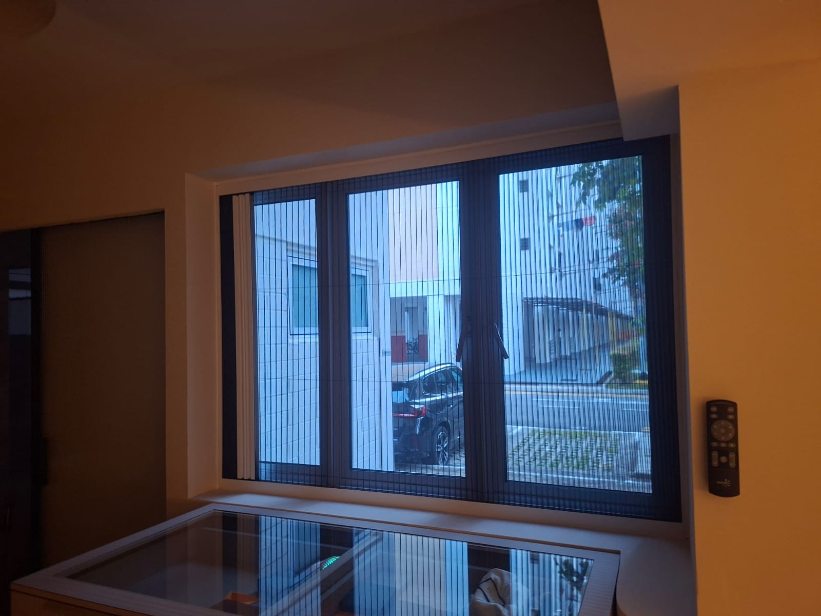 Single folding mosquito screen fully extended across a bedroom window