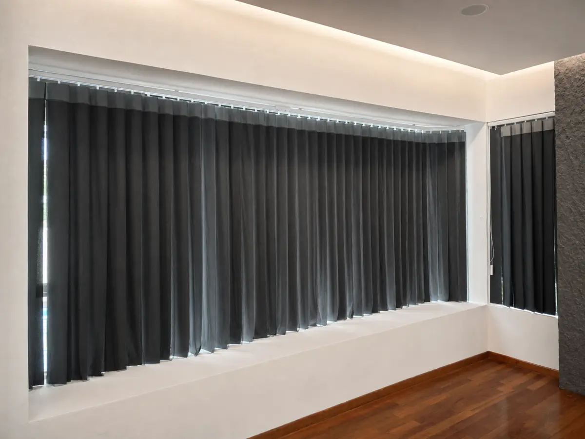Dark vertical blinds installed across indoor windows